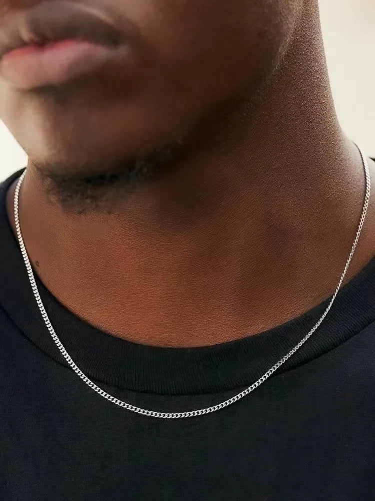Collier chaîne en acier inoxydable argenté porté par un homme, style vintage raffiné.