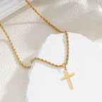 Collier croix élégant porté en extérieur, bijou moderne et intemporel.