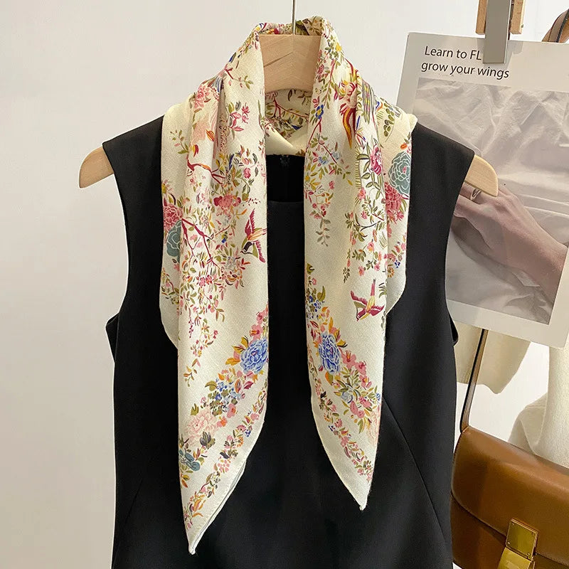 Foulard carré en satin, imprimé multicolore avec motifs floraux et oiseaux raffinés, style botanique chic.