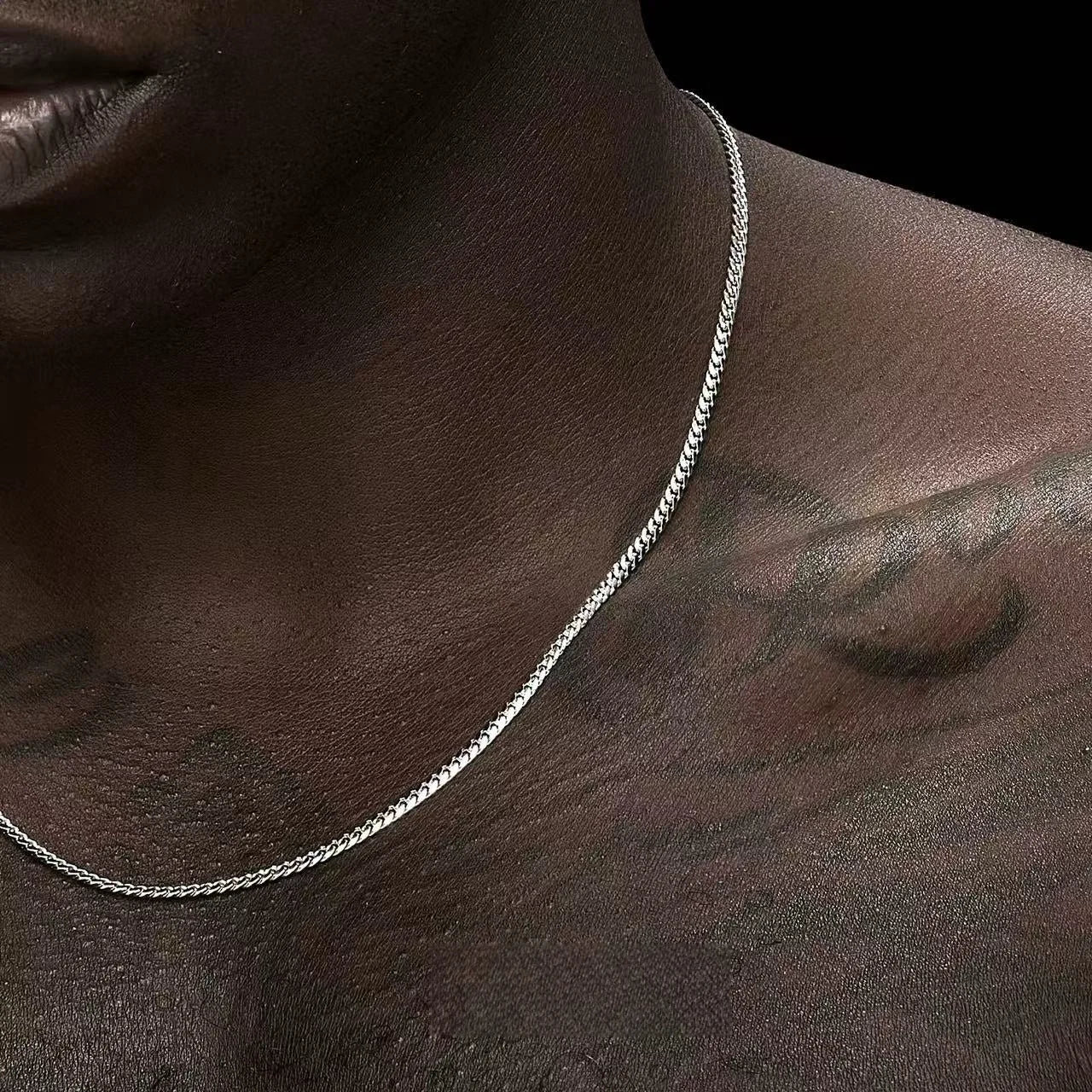 Zoom sur collier à maillons en acier inoxydable, bijou intemporel et robuste.